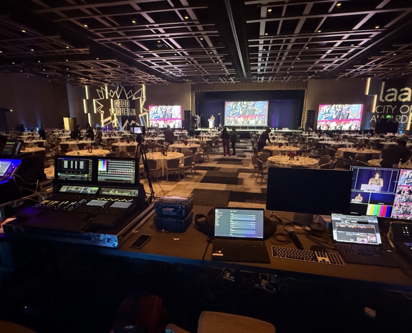 Ballroom awards dinner with three screens and a front-of-house control desk